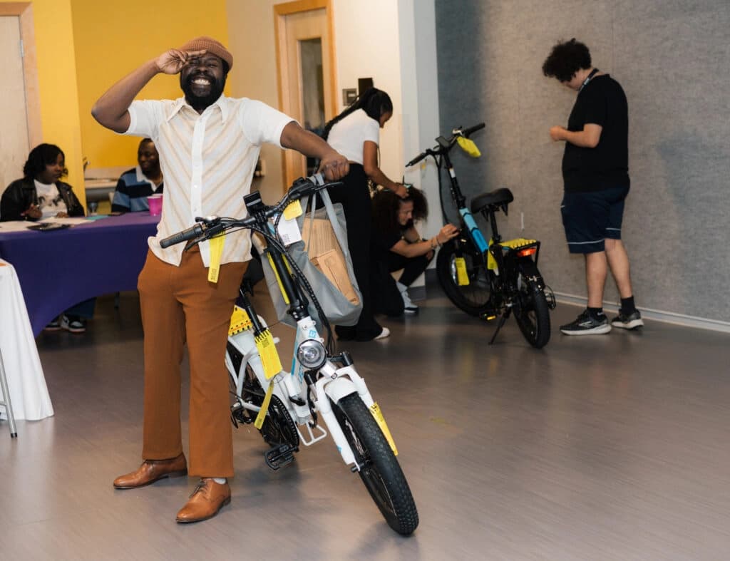 A smiling participant receiving an e-bike at an Ensemble Washington event